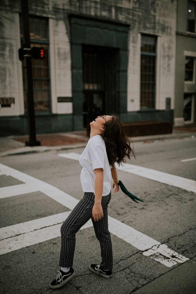 woman walking across street happy